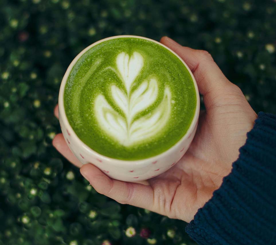 Cup of Matcha Latte with foam art leaf